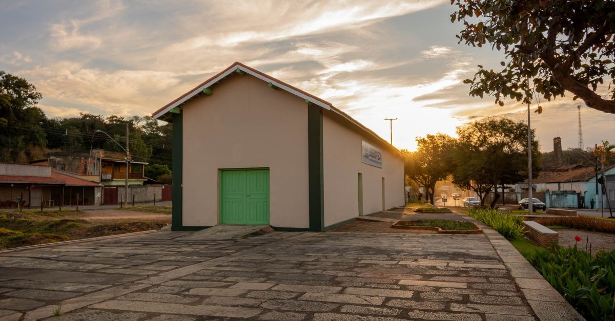 Santa Elena Travel Guide: Sun, Sea, and Rural Heritage Charming historic building with a green door under a vibrant sunset in Santa Luzia, Minas Gerais, Brazil.
