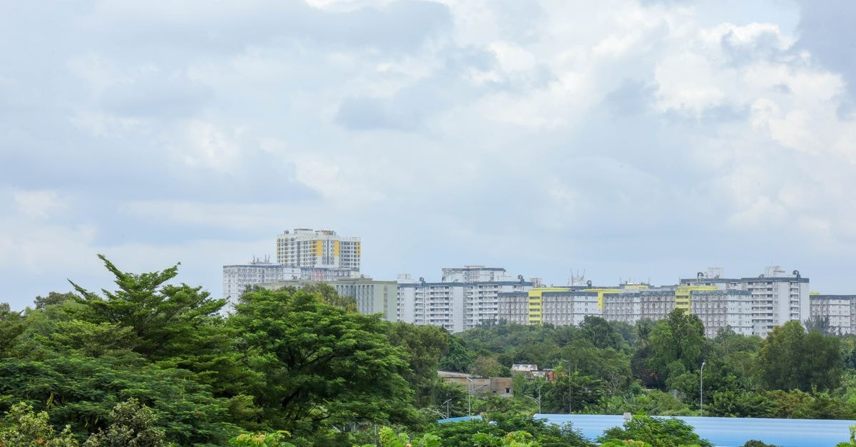 Mount Soche Hotel, Blantyre: Tropical Gardens & a Mandela Legacy Urban cityscape featuring high-rise residential buildings with lush greenery in the foreground under a cloudy sky.