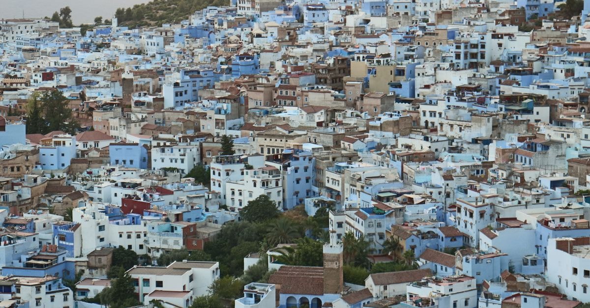 Explore the distinctive blue architecture of Chefchaouen, Morocco in this evocative aerial view.