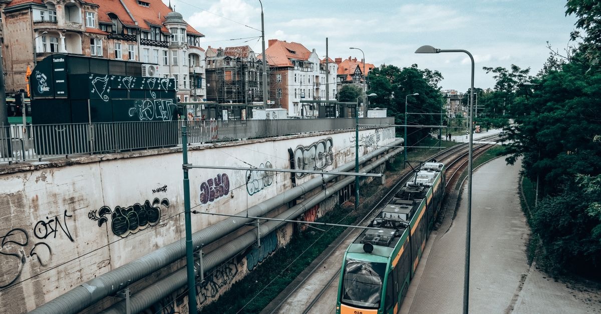 Poznan Travel Guide: Planning Tips, Costs and Things to Do Aerial view of a tram passing by urban buildings in Poznań, Poland. Captures city life and architecture.