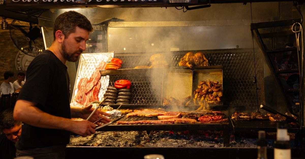 Mendoza Travel Guide: Andes Air, Plaza Walks, and the Grill Chef grilling assorted meats at Cabaña Veronica restaurant, showcasing traditional barbecue techniques.
