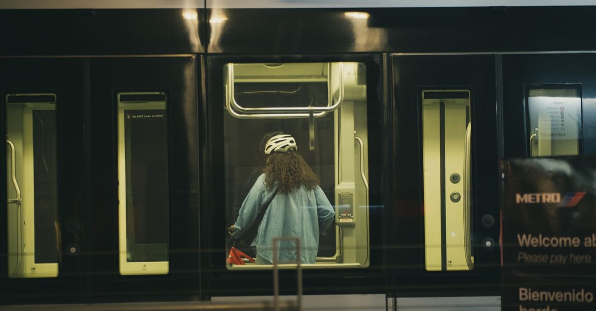 Candid shot of a woman in a helmet on the Houston metro, capturing urban transit life.