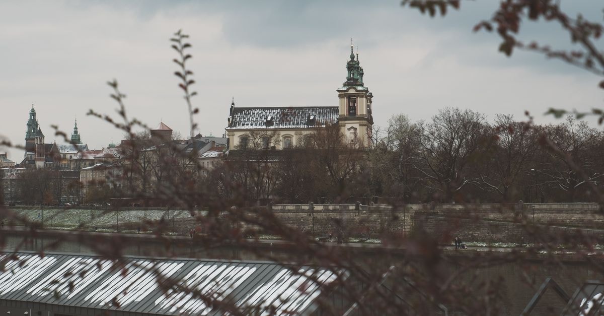 Hotel Rezydent, Kraków: Boutique Stay Steps From the Main Square View of a historic church in Kraków, Poland, with wintry trees in the foreground.