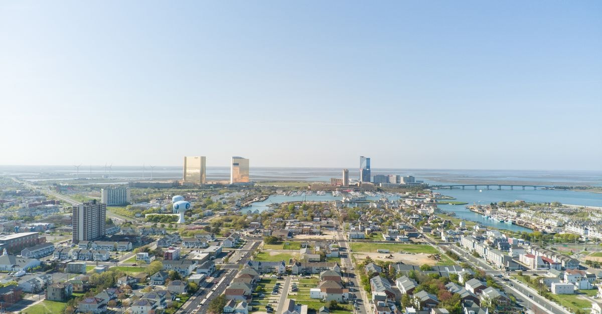 A vibrant aerial shot of Atlantic City, showcasing its bustling cityscape and coastline under clear skies.