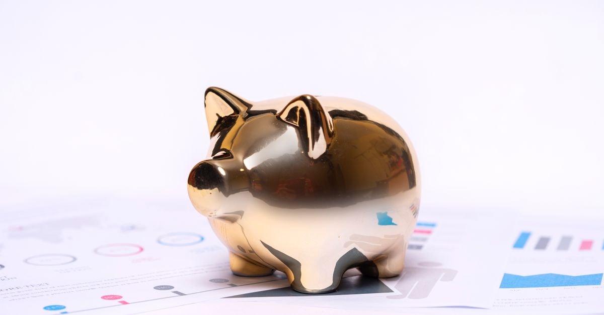 10 年後,1,000 美元的 KKR 投資將價值 6,603.72 美元 財務文件上金色存錢罐的特寫,象徵儲蓄與投資。