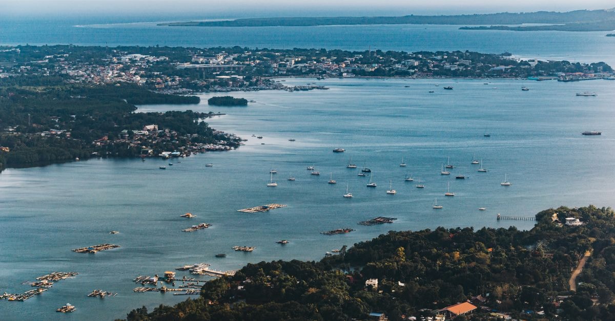Hotel Syariah Minang Jaya, Batam — Sharia-Friendly Stay Near Nagoya Hill Stunning aerial view of a coastal city with sailboats dotting the bay, displaying vibrant scenery and serene waters.