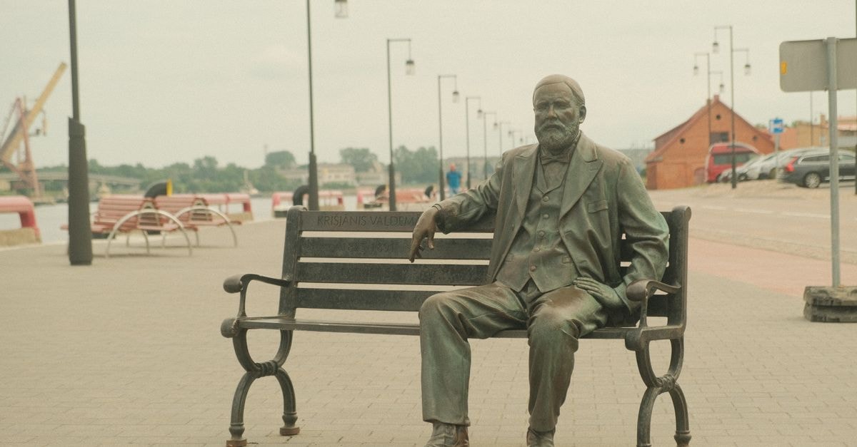 Dzintarjūra in Ventspils: A Central Stay on Ganību iela Bronze statue of Krišjānis Valdemārs sitting on a bench in Ventspils, Latvia.