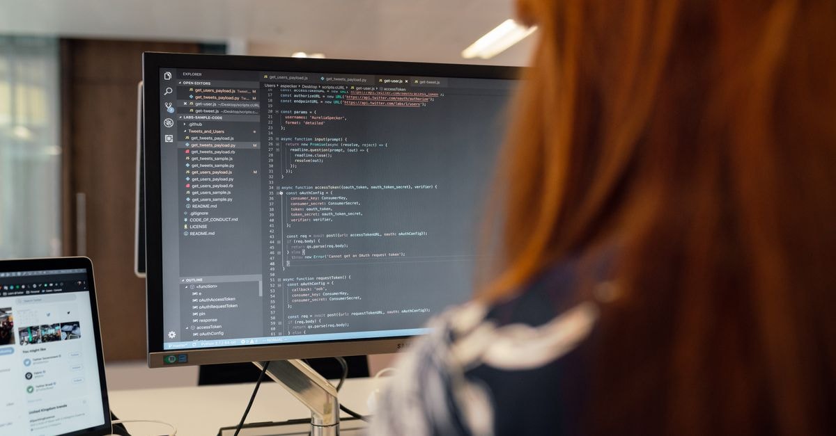 Shopify debuts AI-driven Catalog and Universal Commerce Protocol to expand merchant reach across agent platforms A female engineer works on code in a contemporary office setting, showcasing software development.