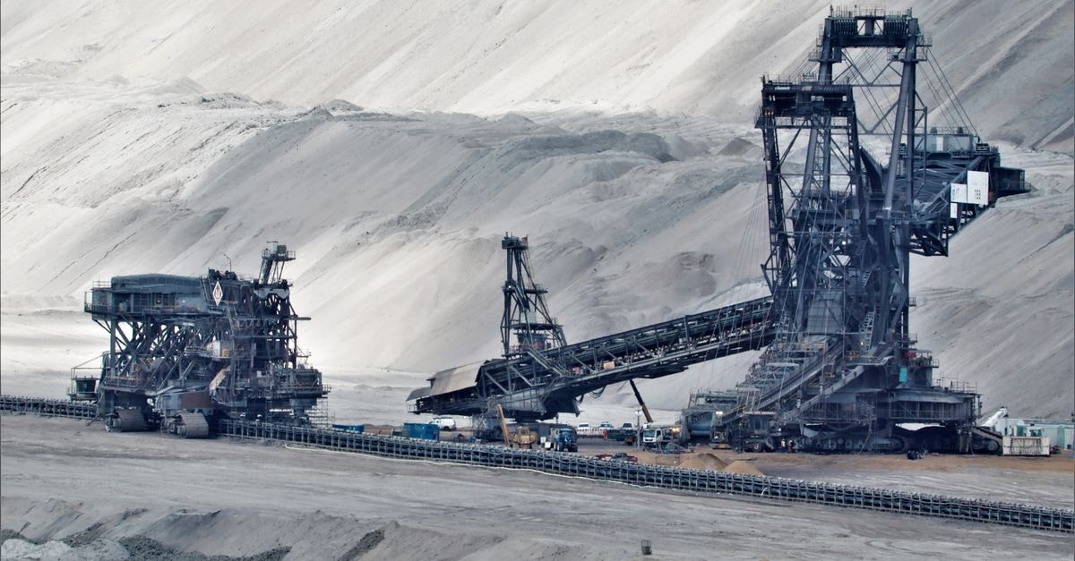Gold surges past $4,500 as Treasury buyback plan rattles bond markets and fuels safe-haven demand A large bucket wheel excavator operates in a vast industrial mining area, illustrating heavy machinery in action.