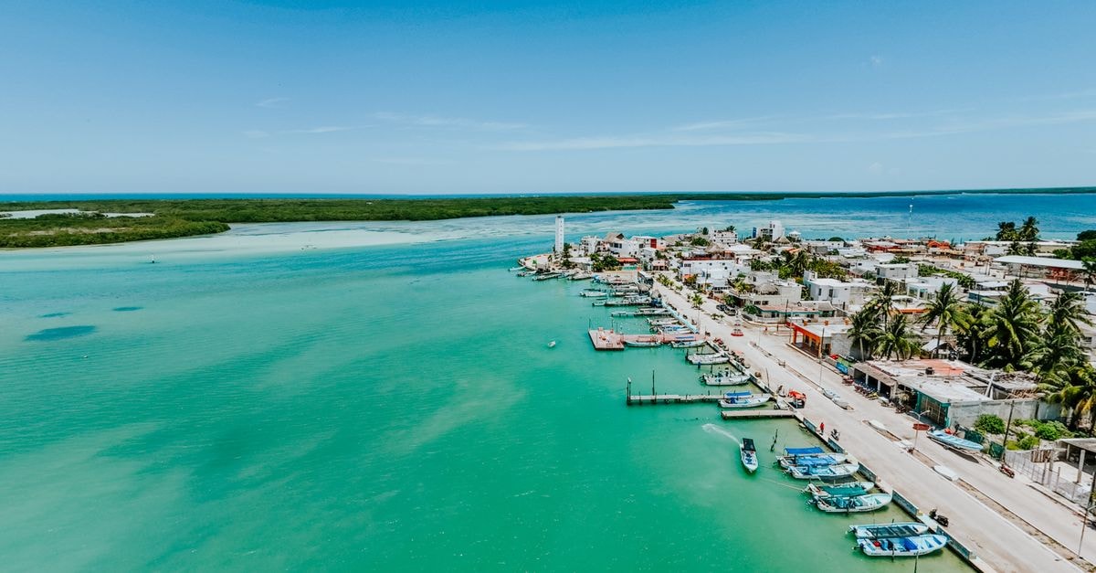 Assomada Travel Guide: Planning Tips, Costs and Things to Do A breathtaking aerial shot of a coastal town and marina with turquoise waters on a sunny day.