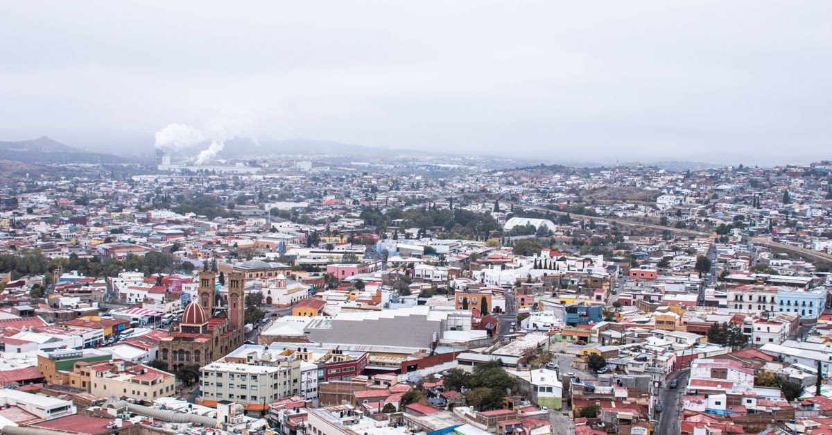 Hotel Ayotla in Xico: A Cuauhtémoc Avenue Stop in Ixtapaluca Aerial view showcasing the vibrant cityscape of Hidalgo del Parral, Mexico with colorful buildings and distant smokestacks.