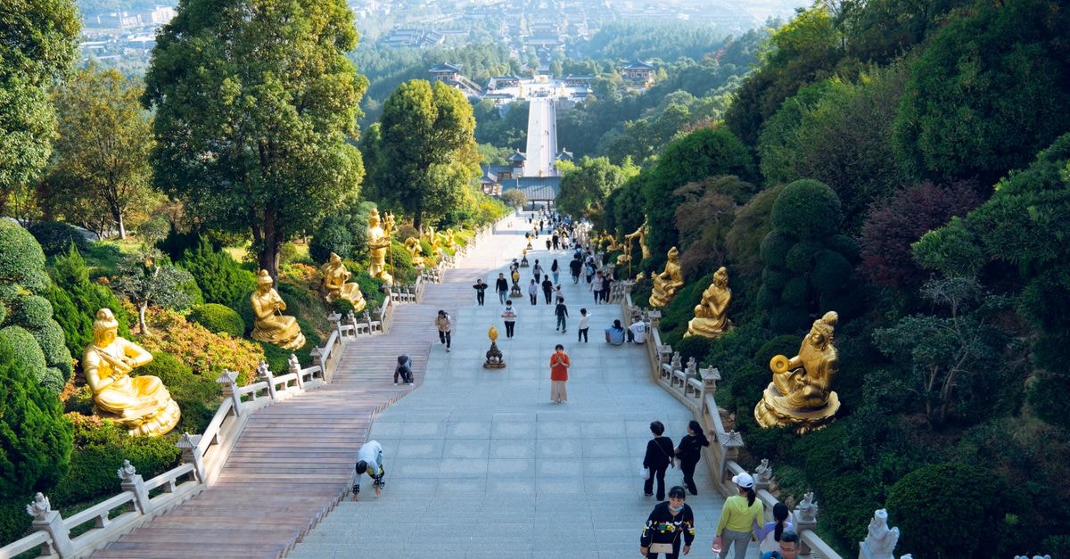 A Ceramic Lover's Travel Guide to Jingdezhen, Jiangxi A serene view of a Buddhist staircase adorned with golden statues in Jiujiang, inviting tourists and travelers alike.