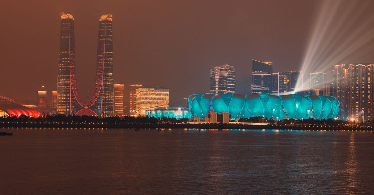 Holiday Inn Express Hefei Downtown in Hefei: A Smart Stay on Changjiang Middle Road Illuminated skyline of Hangzhou featuring modern architecture and vivid lights along the water.