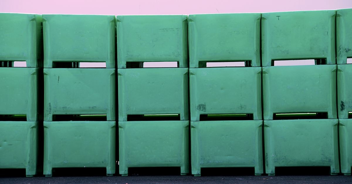 Karat Packaging Inc.: Cash Surge Distorts the Earnings Story Row of green plastic tubs stacked against a pink wall. Industrial and storage concepts.