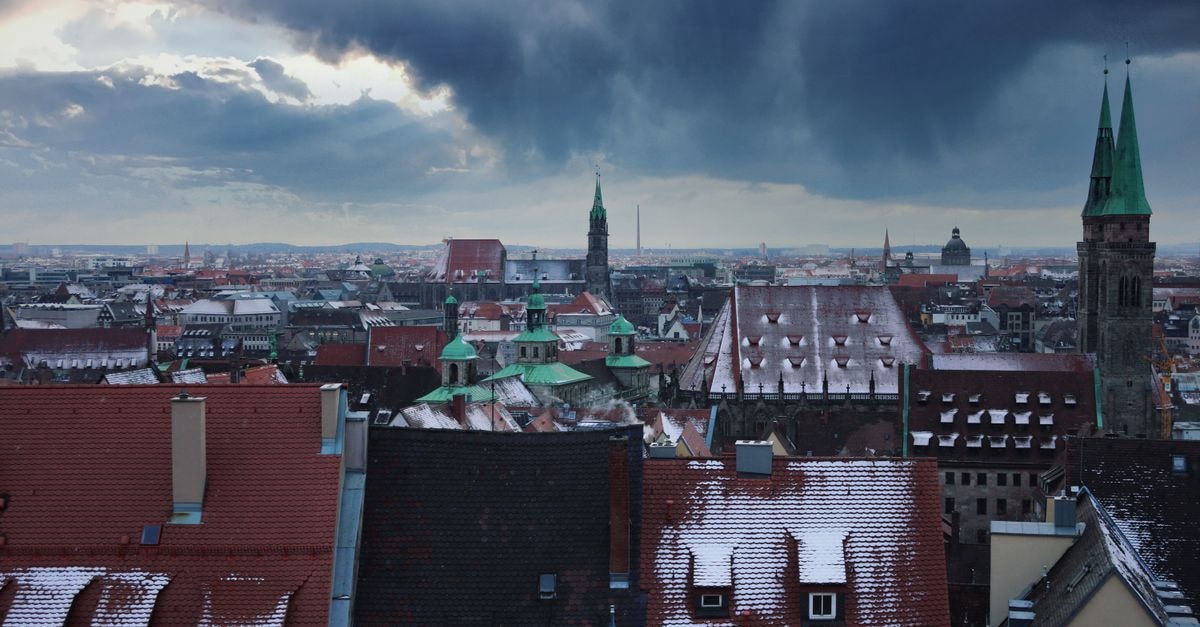 Karl August in Nuremberg: A Boutique Stay in the Augustinerhof Quarter Winter cityscape of Nuremberg with snow-covered rooftops and a dramatic sky.