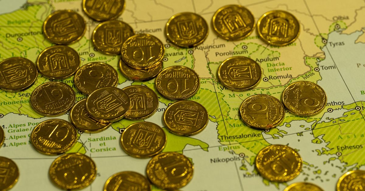 Gold Slides to Seven-Week Low as Global Bond Yields Climb Pile of gold coins placed on top of a detailed geographical map.