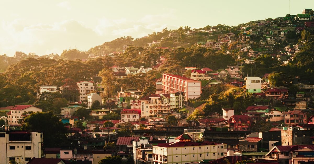 A picturesque hillside town with vibrant rooftops and lush greenery at sunset. Perfect for travel enthusiasts.