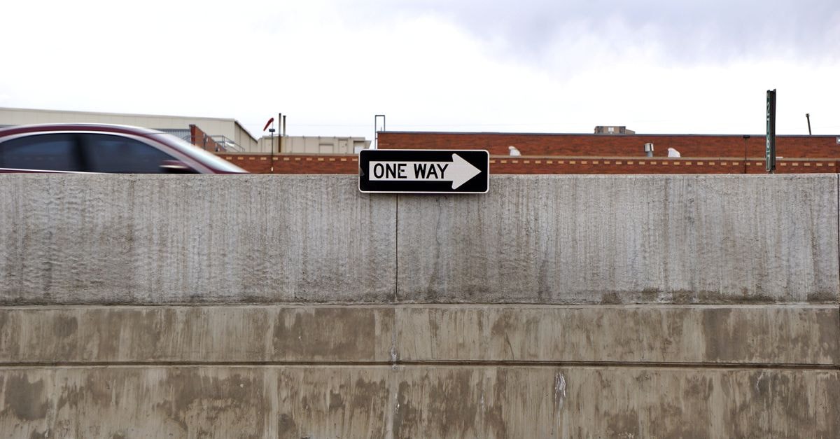 Kaliningrad Travel Guide: Layers of Europe in One City Cityscape featuring a one-way road sign, passing car, and urban concrete wall.