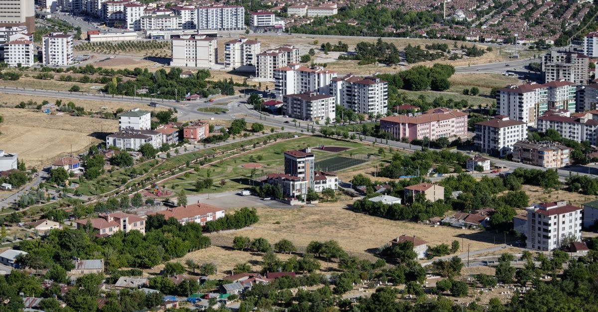 Aerial cityscape of Elâzığ, Türkiye showcasing apartments and greenery in summer.