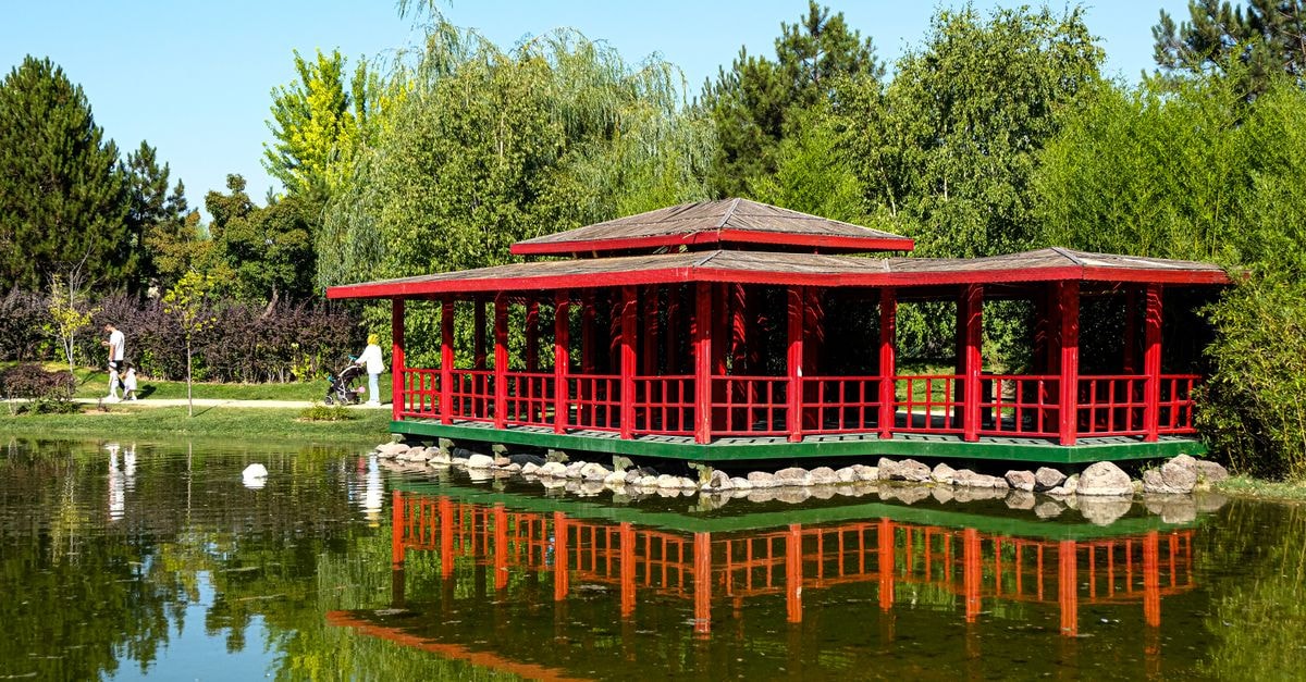 Deeps Hostel Eskişehir in Tepebaşı: A Budget Hostel on Safiyet Sokak A tranquil red pavilion reflecting in a pond surrounded by lush greenery in Eskişehir, Türkiye.