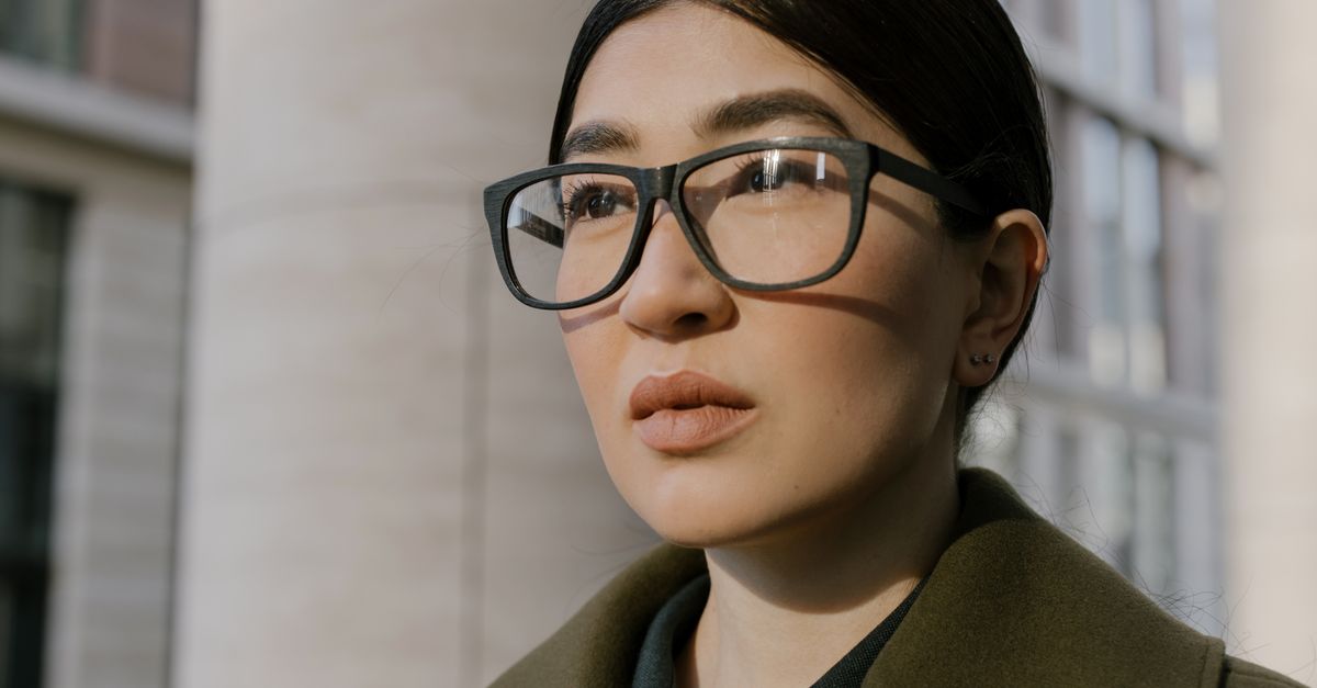 Apple Plans Privacy-Focused Smart Glasses Unveiling at WWDC 2027 Close-up portrait of a confident woman in glasses, exuding professionalism in an urban environment.