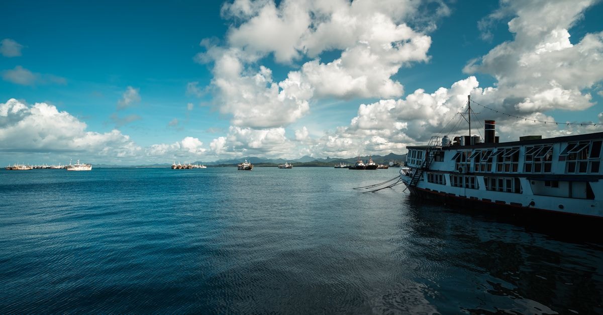 Tranquil scene of boats docked in Suva Harbor, Fiji, under a bright sky.