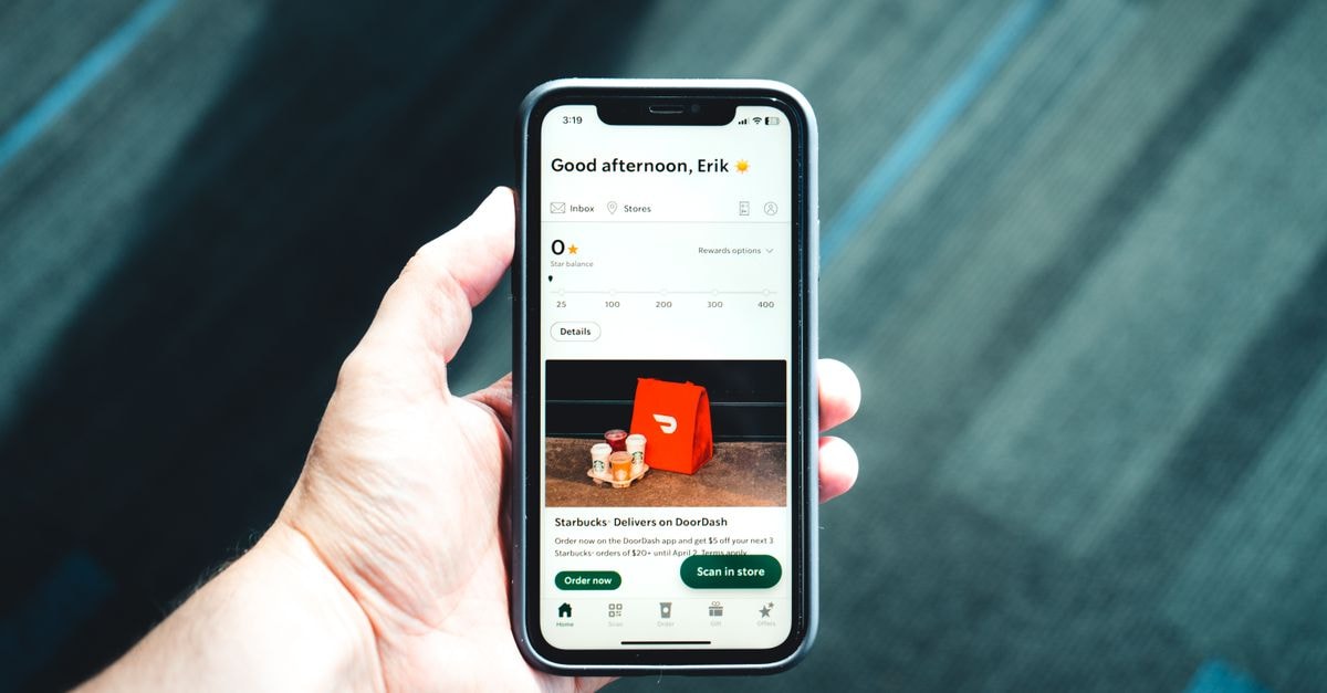 DoorDash 將以 170 億美元收購 Instacart,待完成交割 特寫一部握在手中的智慧型手機,螢幕顯示配送應用程式介面,突顯現代電子商務。