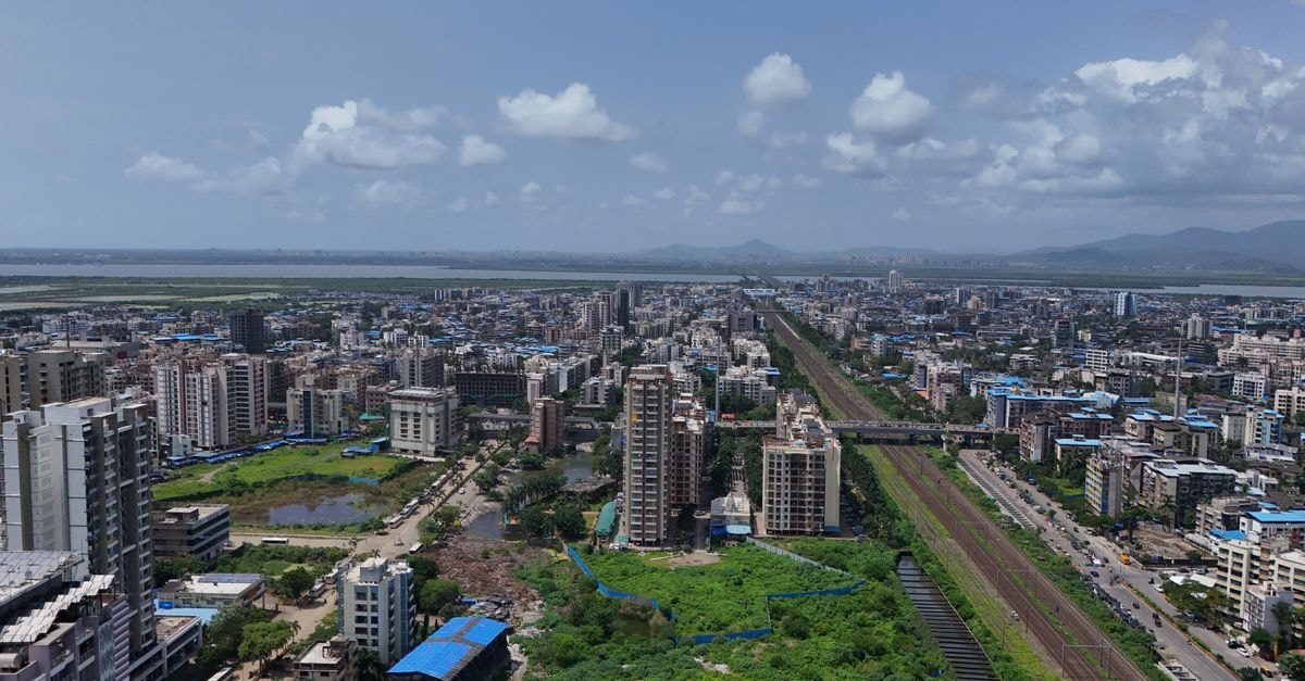Holiday Inn Express Pune Pimpri: Smart Stays Near the Industrial Hub Stunning aerial shot of Mumbai's skyline, showcasing the bustling cityscape and vivid greenery under a clear blue sky.