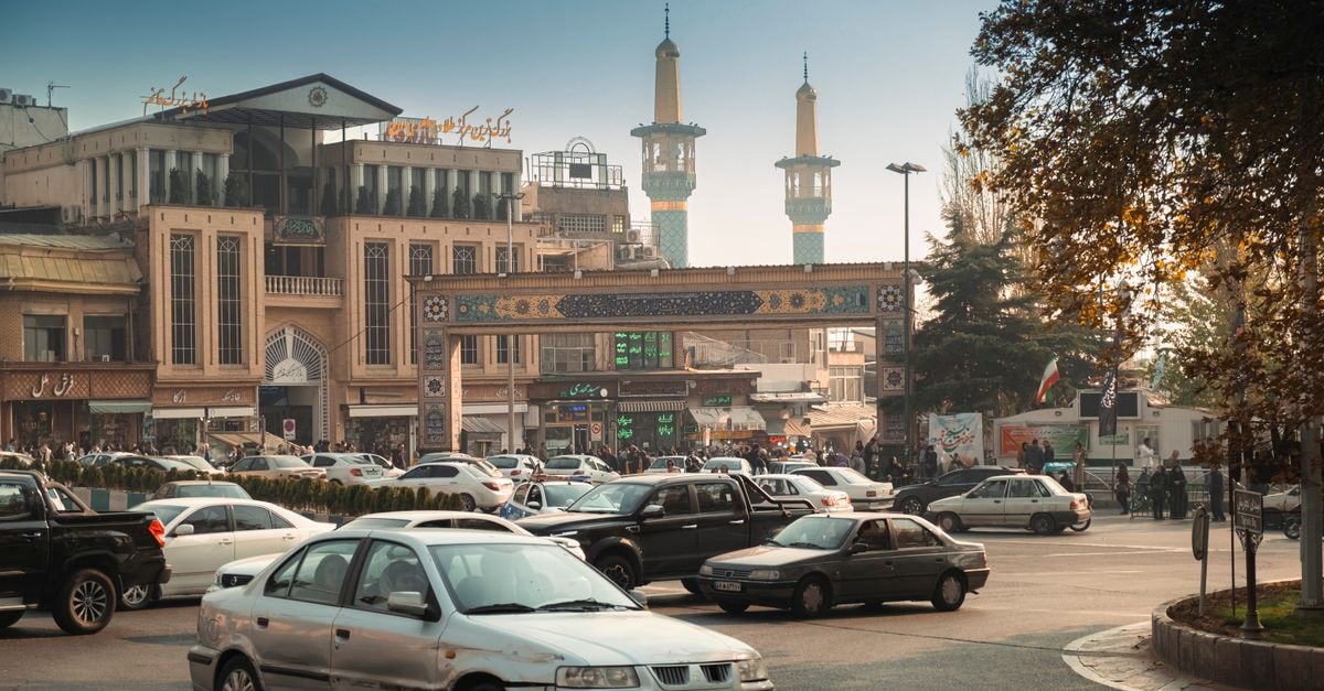 Tehran Travel Guide: Reading the City Before You Arrive Bustling Tehran street scene with cars, mosque minarets, and traditional architecture.