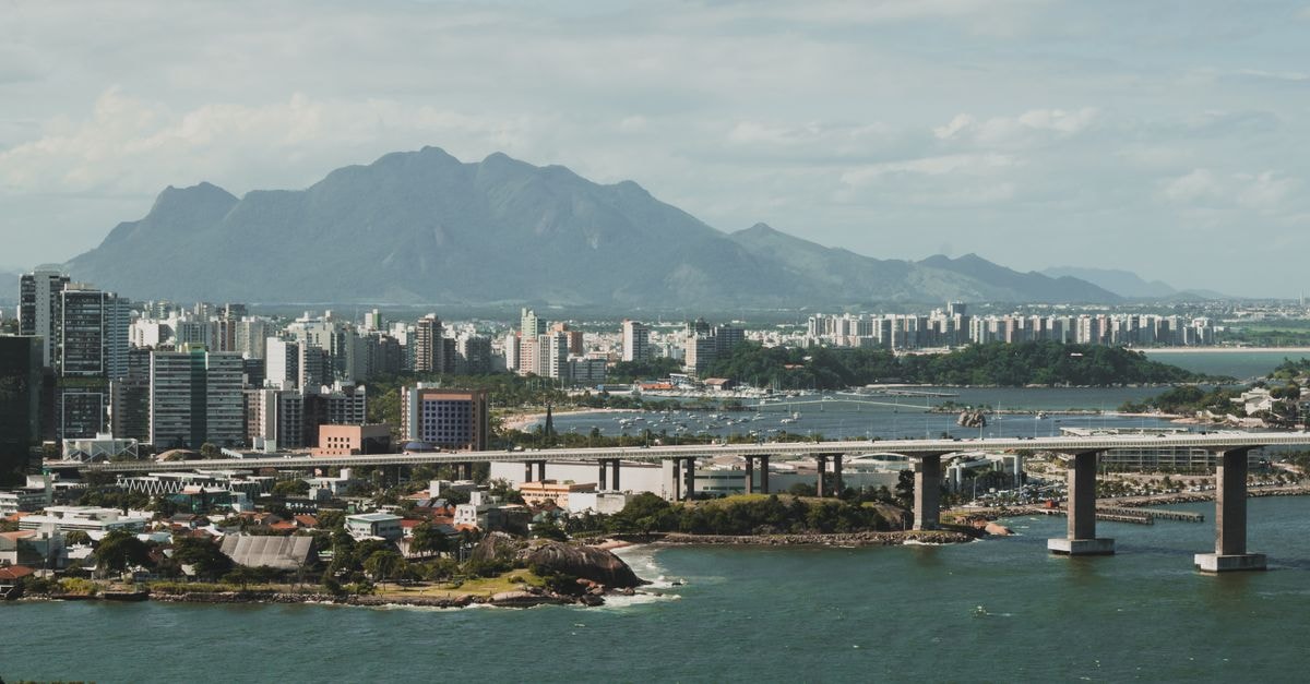 Barra da Tijuca Travel Guide: Planning Tips, Costs and Things to Do Stunning aerial view of Vitória city with mountains and a bridge over the river.