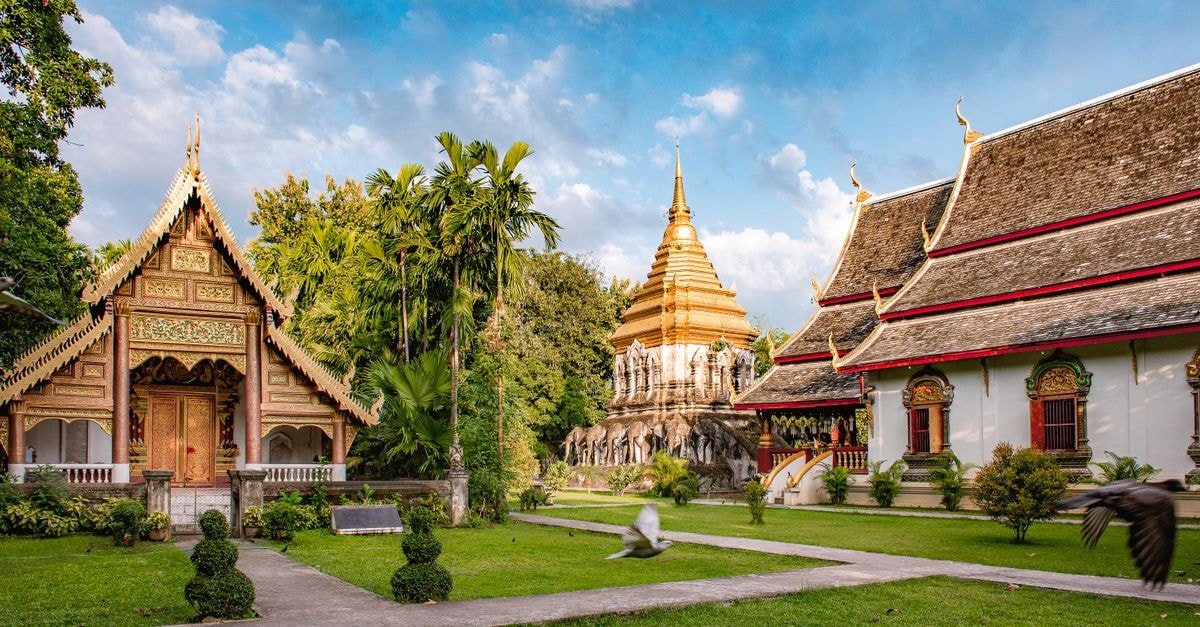 Green Sleep Hostel, Chiang Mai — Steps From the Sunday Walking Street A beautiful view of Wat Chiang Man temple in Chiang Mai, Thailand, surrounded by lush greenery.