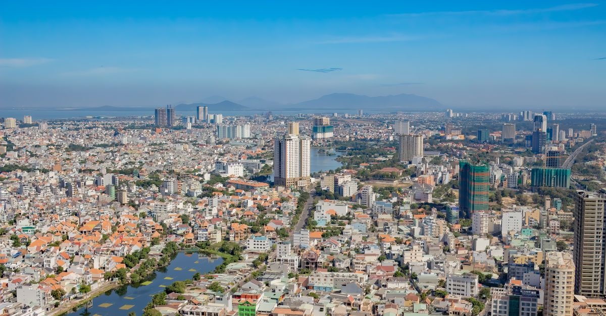 High-angle view of a sprawling cityscape with skyscrapers under a clear blue sky.