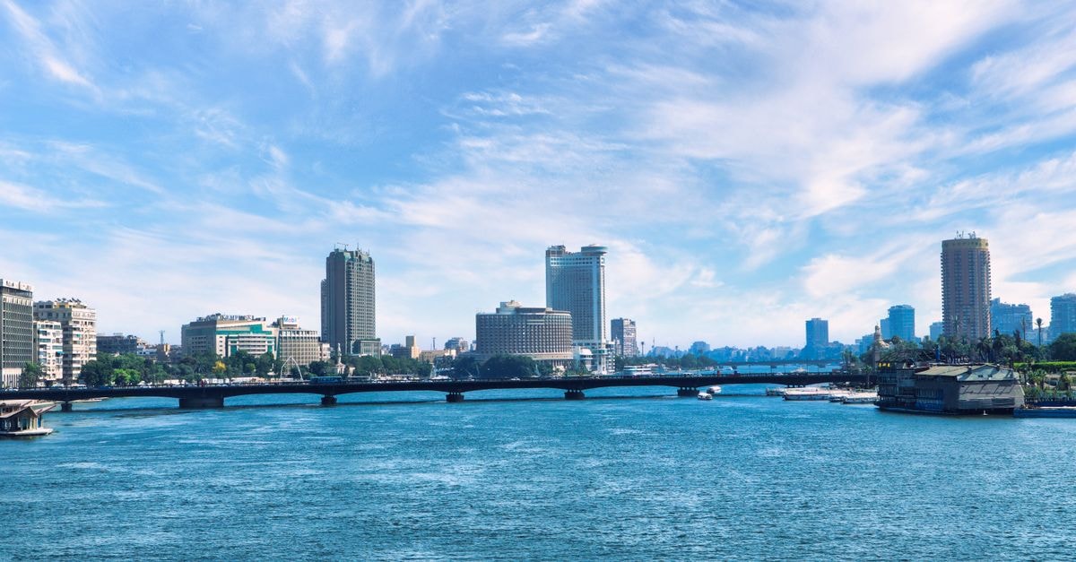 Royal Maxim Palace Kempinski, New Cairo — A Palatial Stay in Egypt's East Discover the stunning Cairo skyline with the serene Nile River and a clear blue sky backdrop.