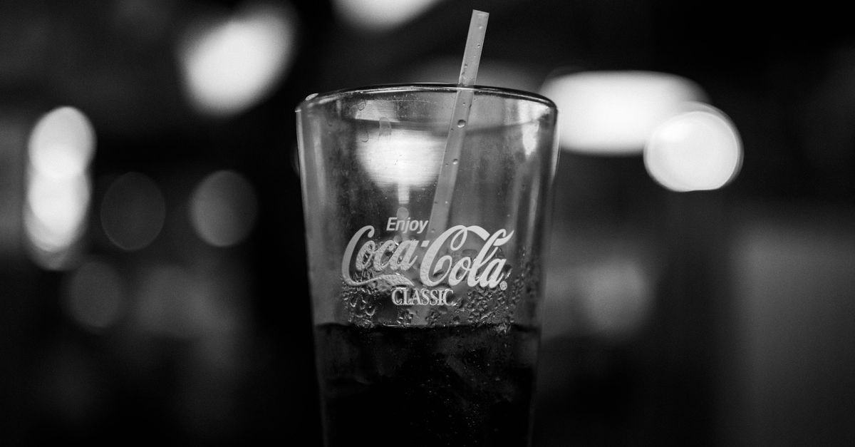 Coca-Cola Sees Reshuffling Among Institutional Holders, With Funds Reporting Both Buys and Trims in Q2 Black and white photo of a Coca-Cola glass with a straw, capturing classic branding.