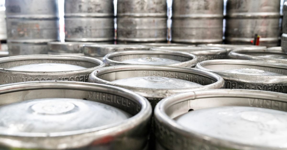 J.P. Morgan 重申 Anheuser-Busch InBev「買進」評級,目標價為 €79.88 一排排鋼製啤酒桶堆放在啤酒廠倉庫中,準備配送。