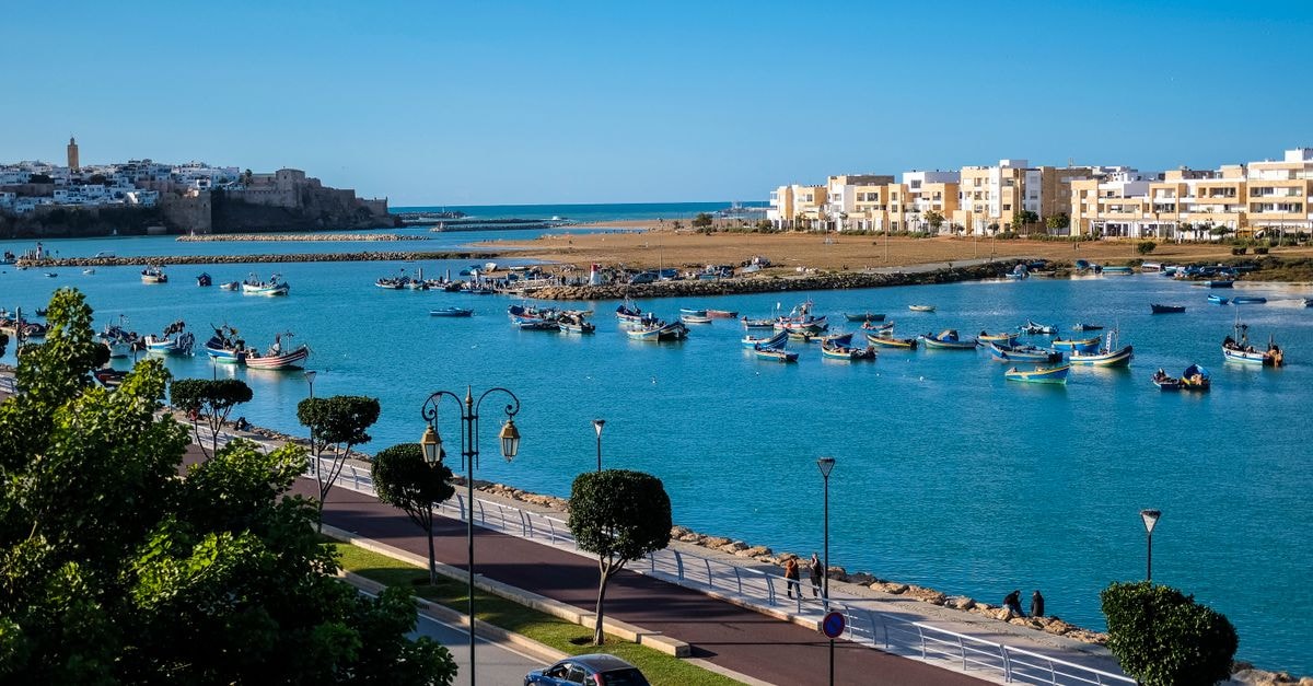 Explore the vibrant harbor of Rabat with traditional boats and coastal architecture.