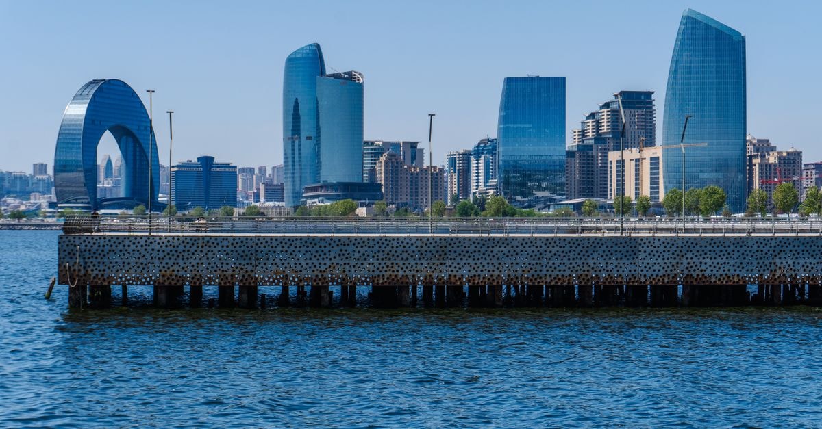 Stunning view of Baku's modern skyline along the waterfront, featuring iconic architecture and blue water.