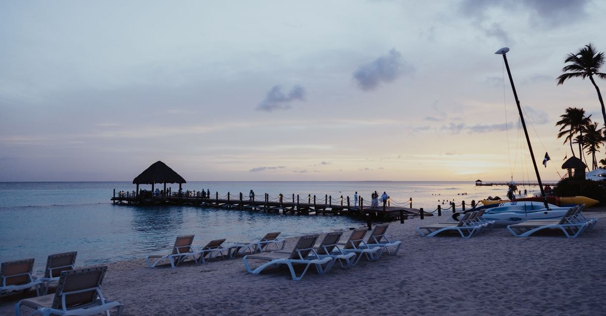 San Andrés Travel Guide: Planning Tips, Costs and Things to Do Relaxing beach scene with sunbeds and pier during sunset, perfect for travel inspiration.