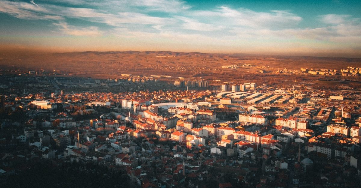 Pristina travel guide: a compact capital worth slowing down for Aerial view of a cityscape during sunset with vibrant lighting.