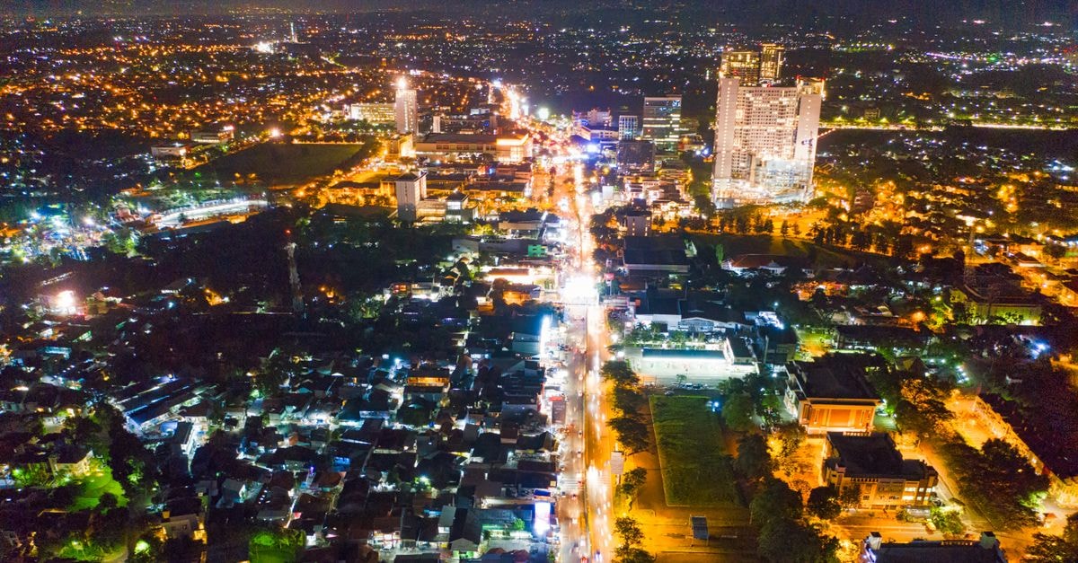 Delonix Hotel, Karawang — Japanese Ofuro and Garden Views A captivating aerial view of a city at night with illuminated streets and bustling urban life.