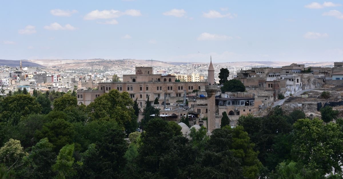 Mosul Travel Guide: Heritage, History, and How to Get Around Scenic view of the historic cityscape of Şanlıurfa, Türkiye, with lush greenery and old architecture.