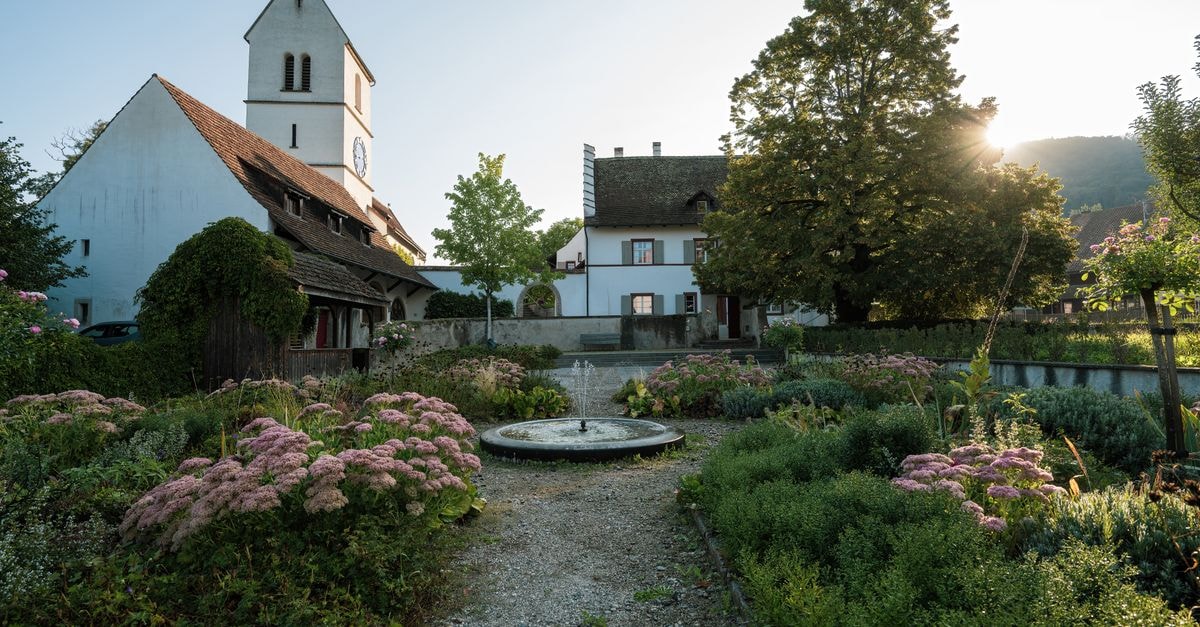 Picturesque church with a lush garden bathed in warm sunlight.