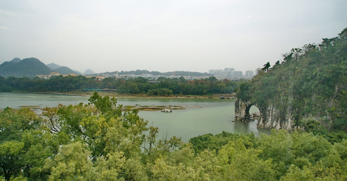 Hechi travel guide: caves, river valleys and slow Guangxi days A beautiful landscape of Elephant Trunk Hill and surrounding trees in Guilin, China.