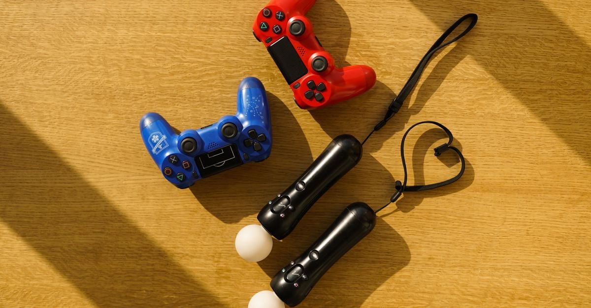 Captain Tsubasa 2: World Fighters launches on Switch, PS5, Xbox Series X|S and PC High angle view of gaming controllers on a sunlight-illuminated wooden table.