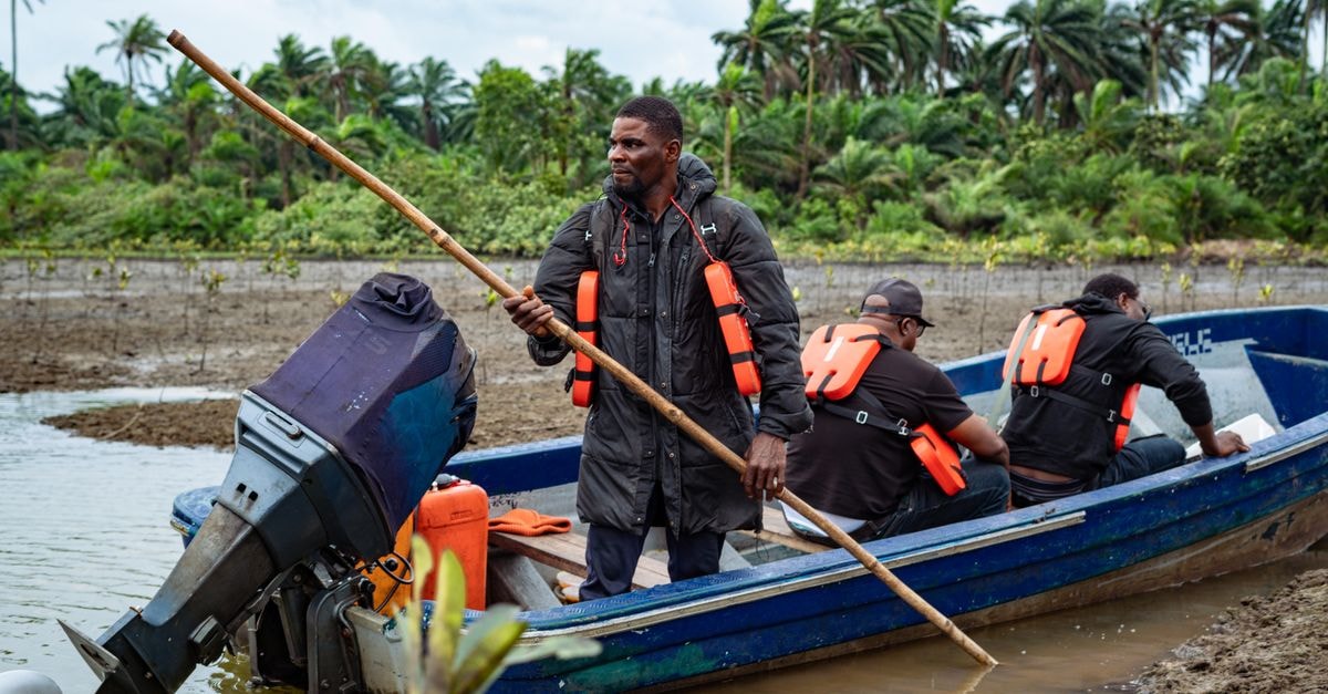 Maradi Travel Guide: A Southern Niger Trading Hub Fishermen in a motorized boat navigating a river, wearing life jackets, in Port Harcourt, Nigeria.