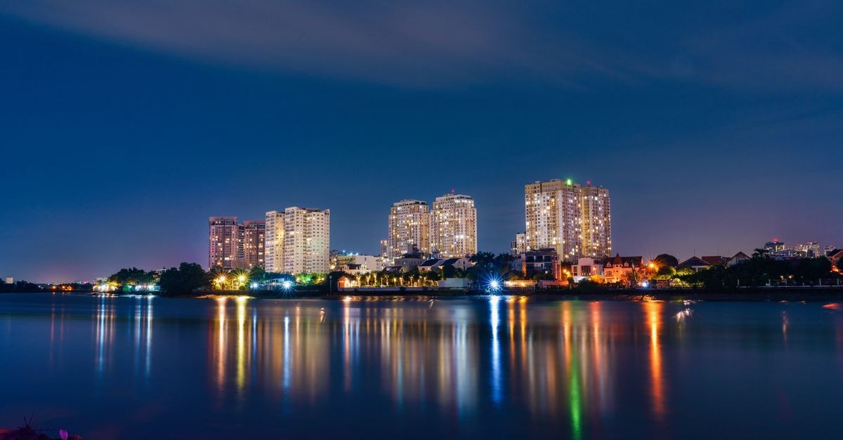 Stunning long exposure of Ho Chi Minh City skyline reflecting on water at night.