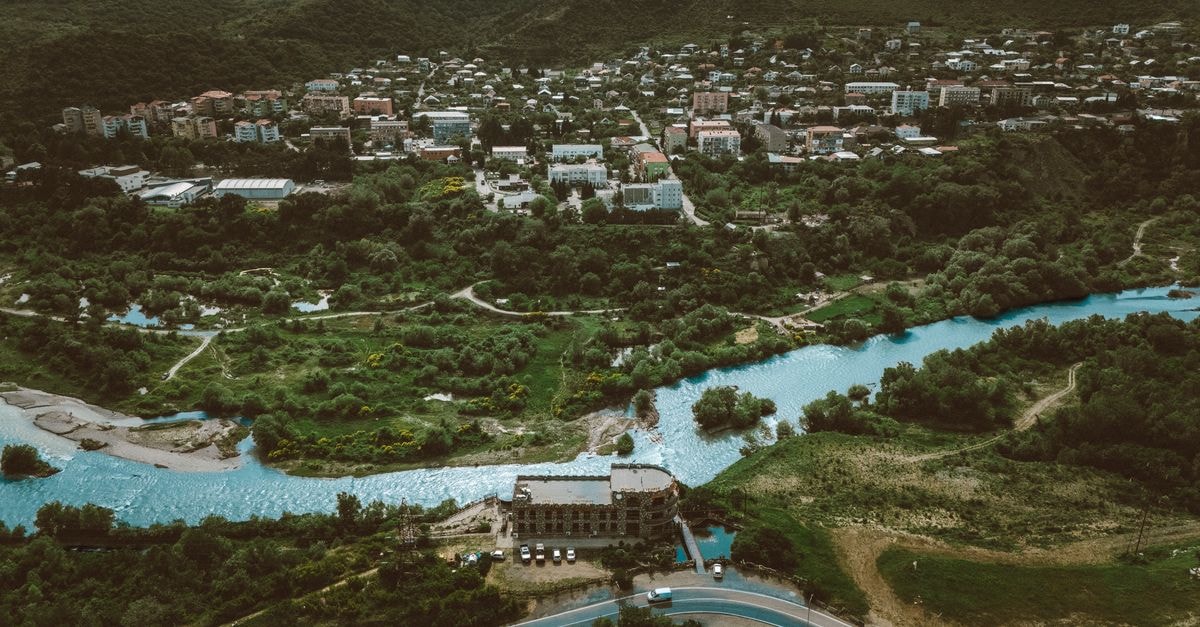 Tillabéri Travel Guide: Planning Tips, Costs and Things to Do Stunning aerial view of a lush Georgian landscape with a river and town in the background.