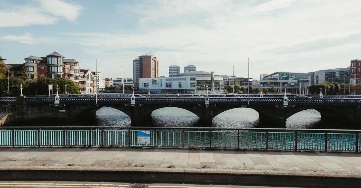 DoubleTree by Hilton Belfast City Ten Square in Belfast: A Linen Quarter Landmark Reborn Scenic view of a bridge over River Lagan with Belfast cityscape in Northern Ireland, UK.