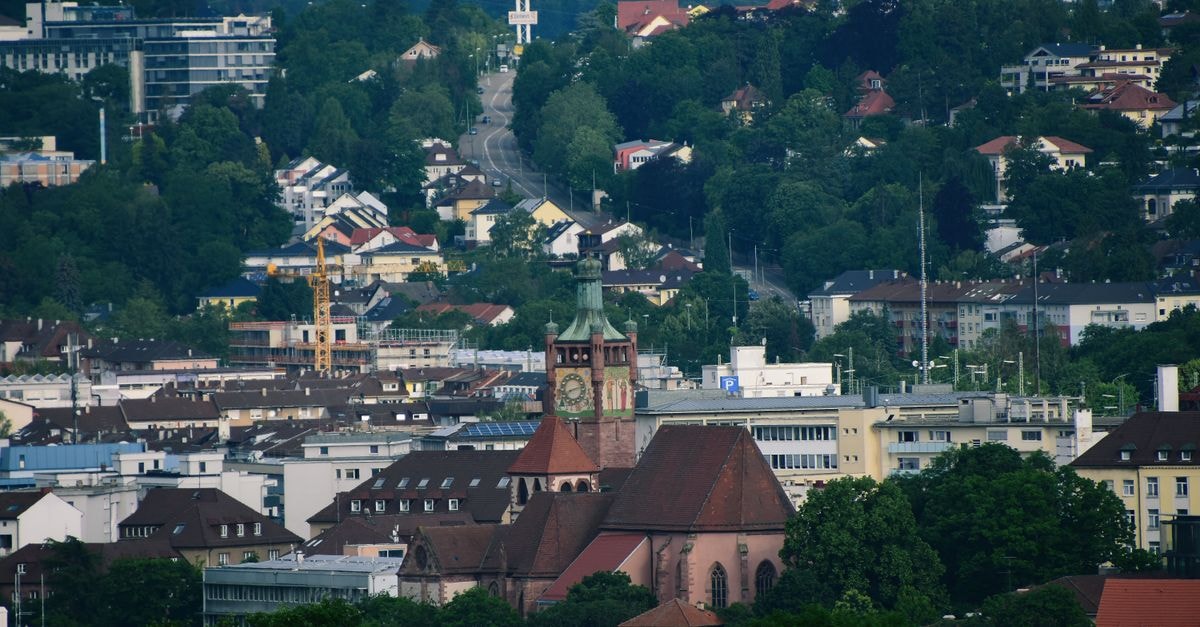 Tgèsa Salep in Aarau: A Quiet Guest House on Dossenstrasse A picturesque view of Pforzheim's cityscape featuring a historic church surrounded by lush greenery.