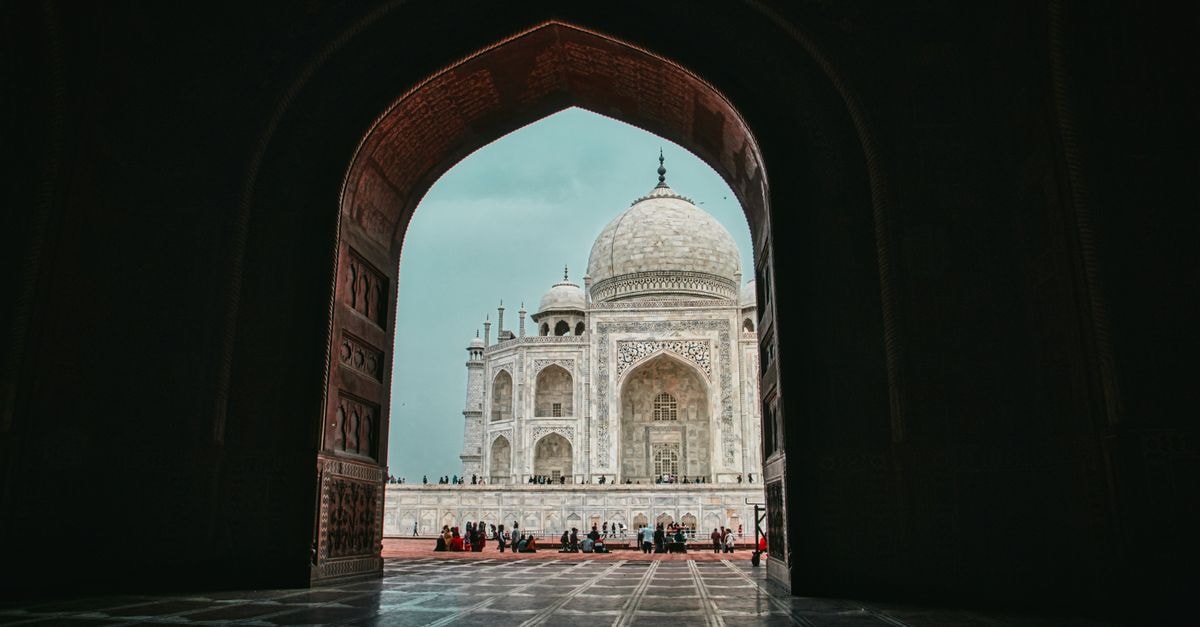 Sai President Hotel, Agra — Heritage Stay Near M.G. Road Low angle view from arched entrance on mausoleum mosque Taj Mahal in India